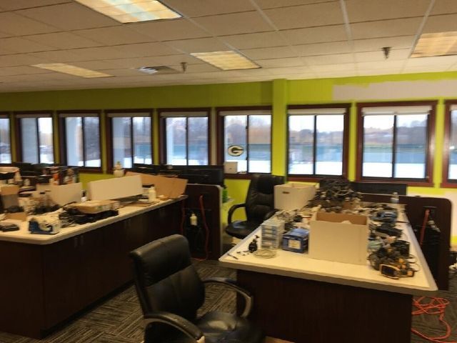 A room with a lot of windows and desks and chairs