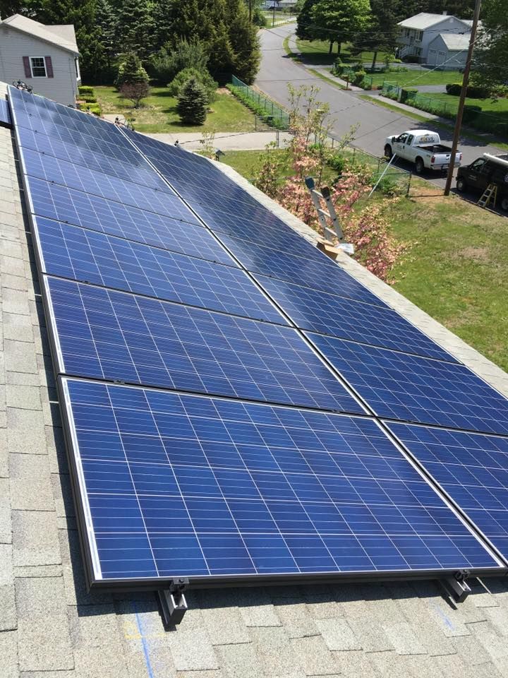 Solar panels installed on a sloped rooftop in a suburban neighborhood