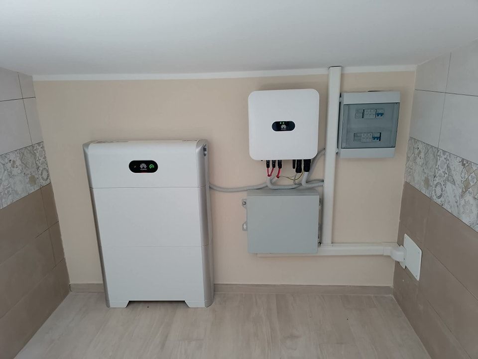Apparecchiature di servizio montate a parete in una stanza piastrellata con pavimento beige e mobili bianchi.