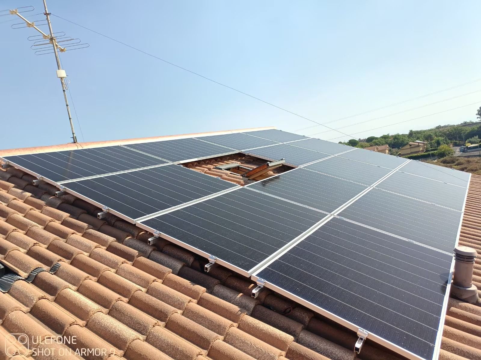Pannelli solari installati su un tetto di tegole, con un'apertura centrale a vista.