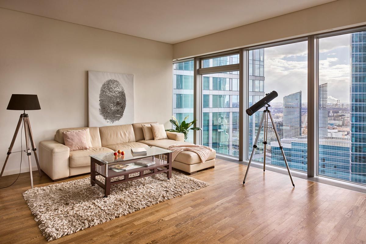 A living room with a couch , coffee table , and telescope.