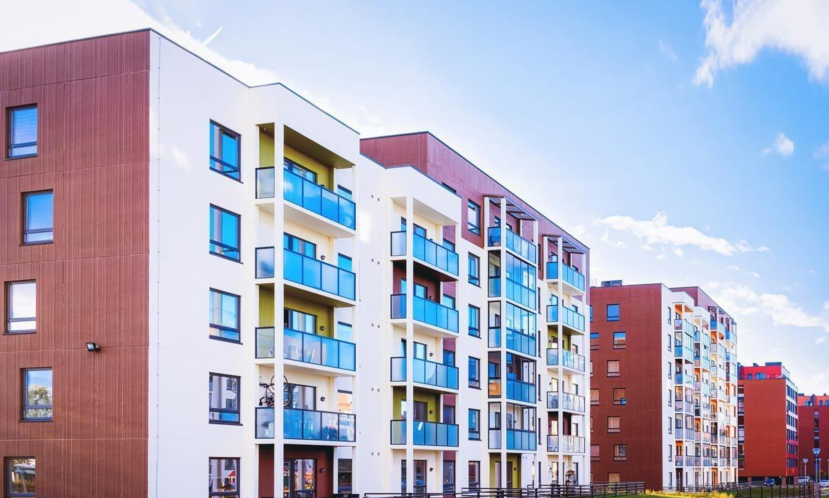 A row of apartment buildings with blue balconies on a sunny day. A row of apartment buildings with blue balconies on a sunny day.