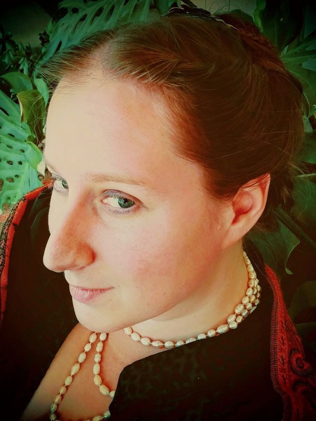 A close up of a woman wearing a pearl necklace