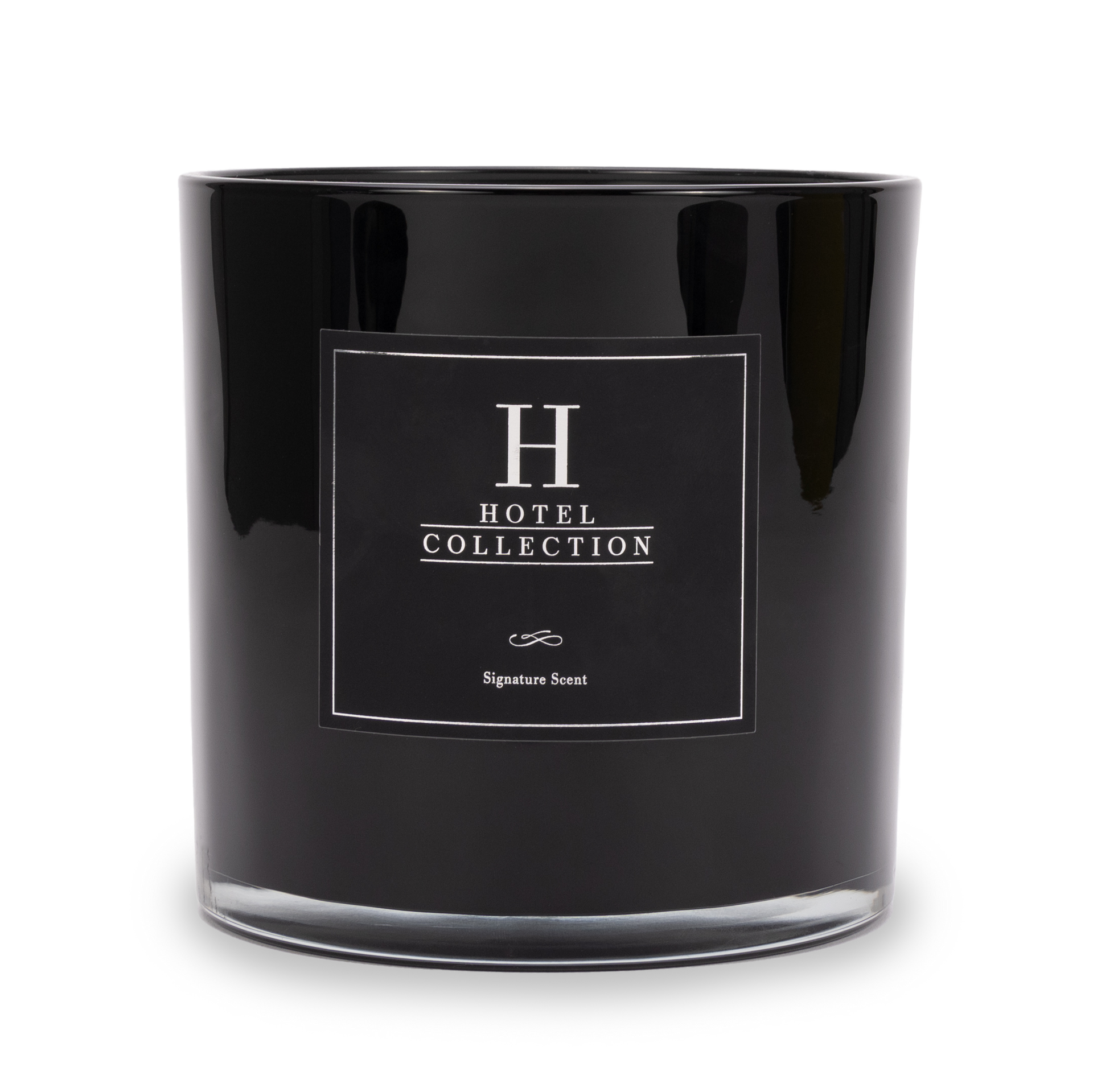 A black candle with a white label that says hotel collection