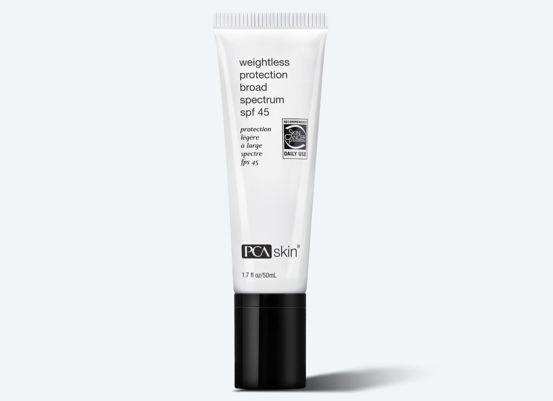 A tube of lotion is sitting on a white surface.