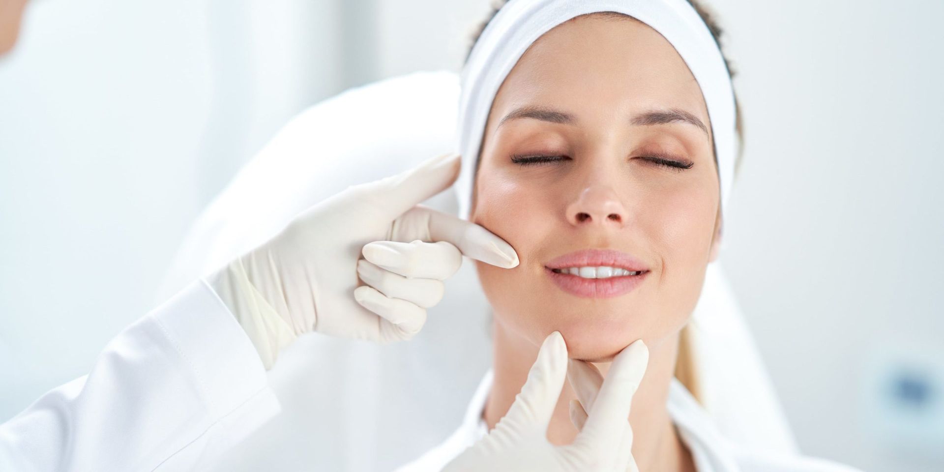 a woman is getting her face examined by a doctor .