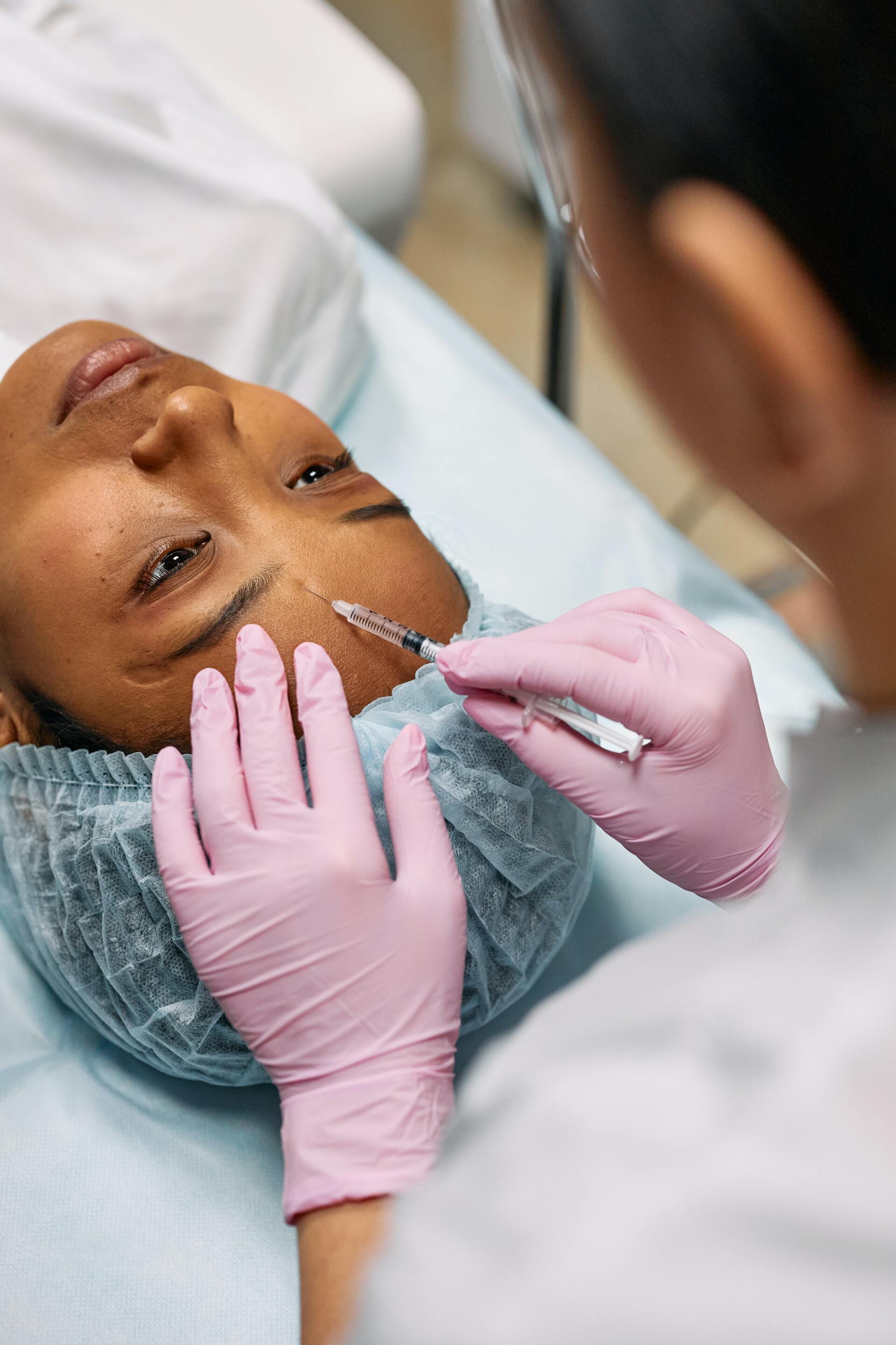 a woman is getting a botox injection in her face .