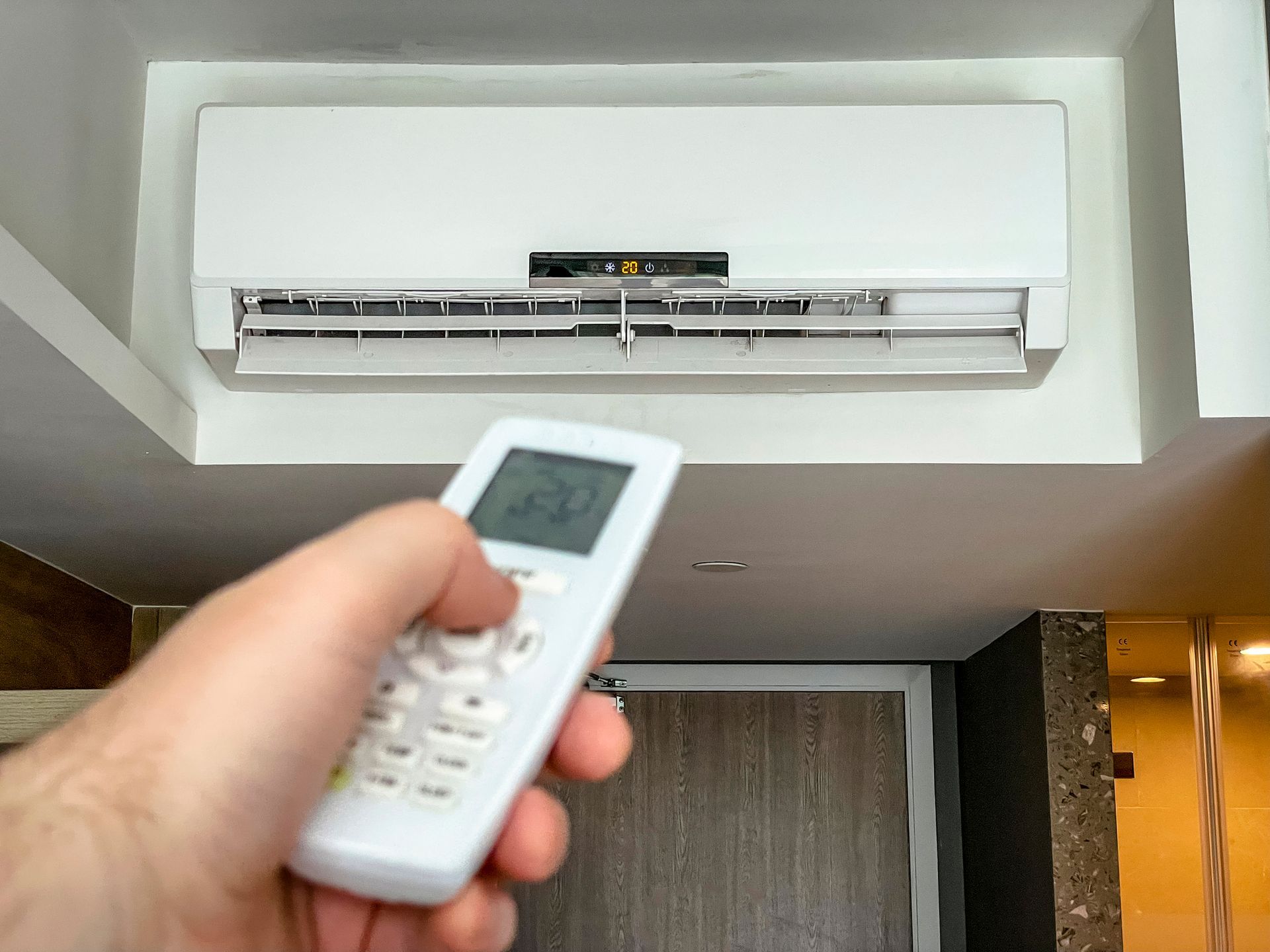 A Person Is Holding A Remote Control In Front Of An Air Conditioner — St. George, UT — Artic Sun