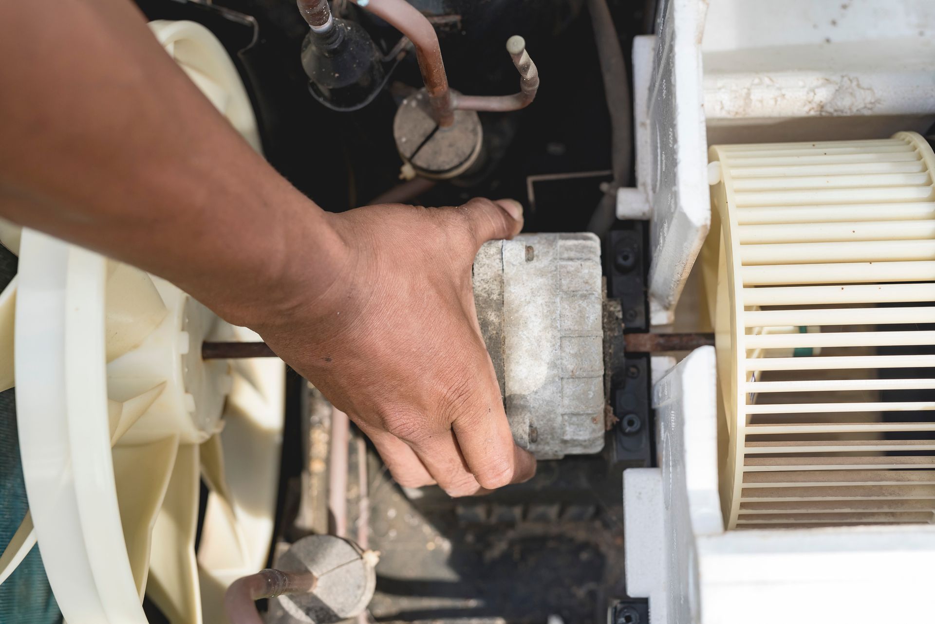 A Person Is Working On An Air Conditioner With A Screwdriver — St. George, UT — Artic Sun