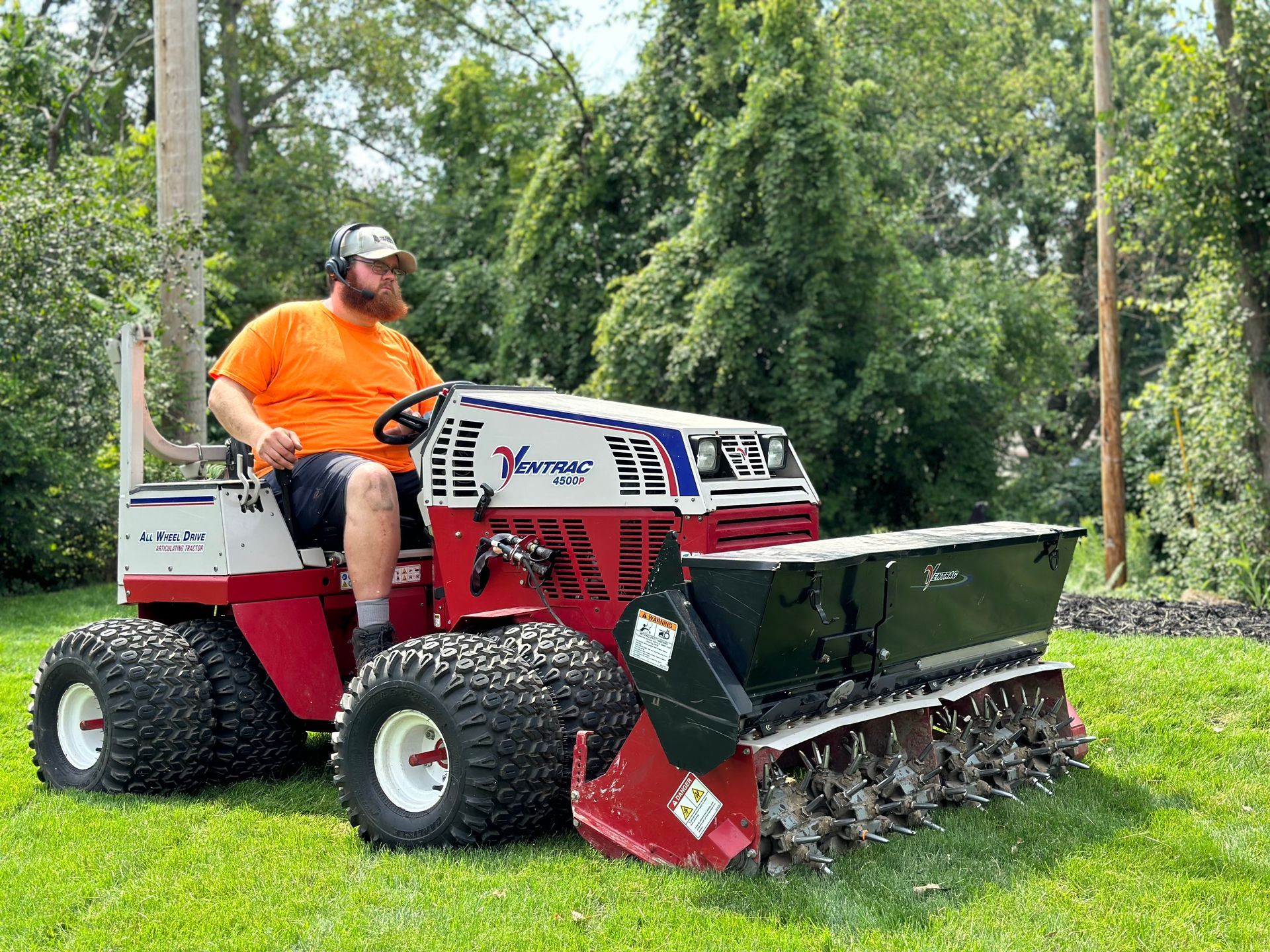 A red lawn mower is sitting on top of a lush green lawn.