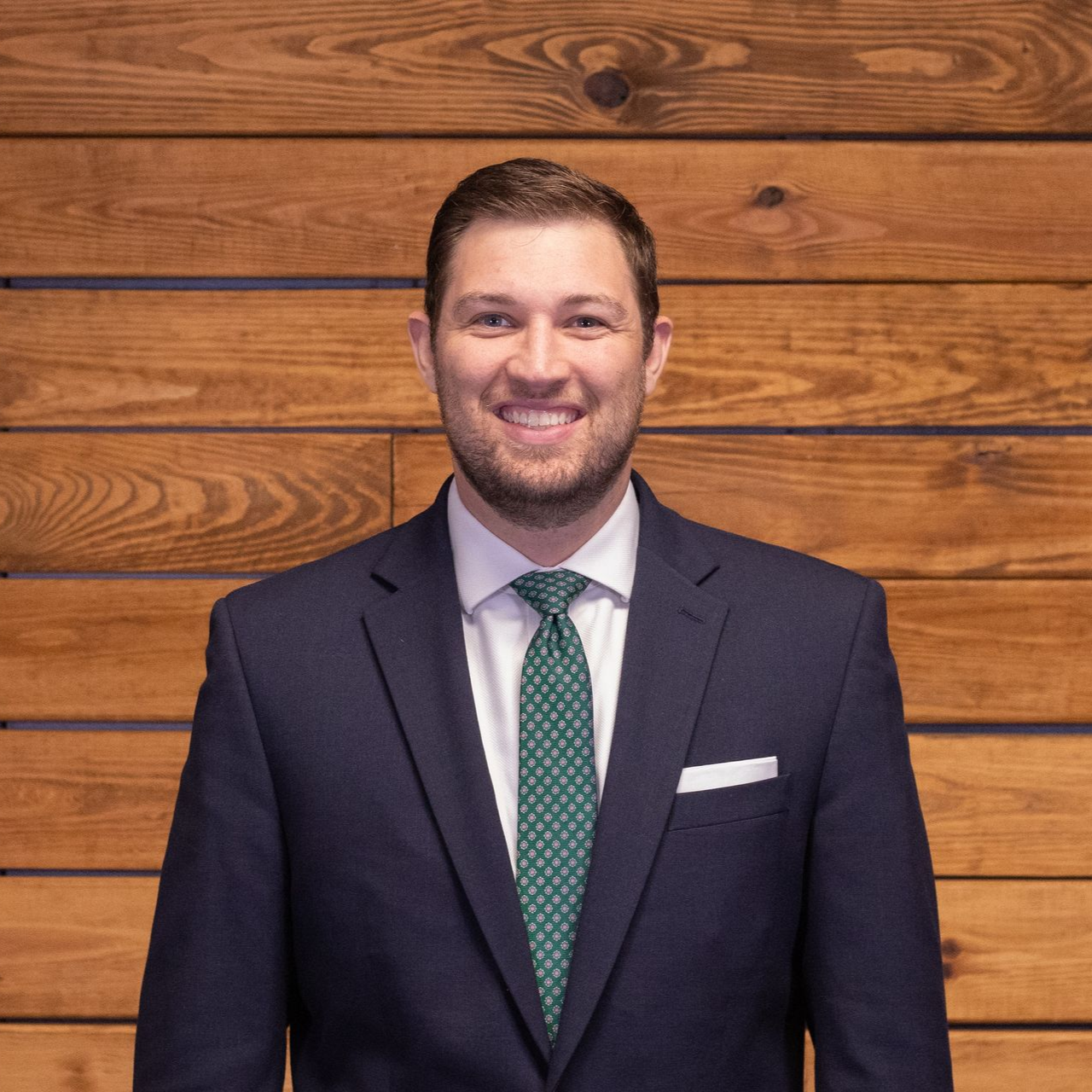 A man in a suit and tie is smiling for the camera.