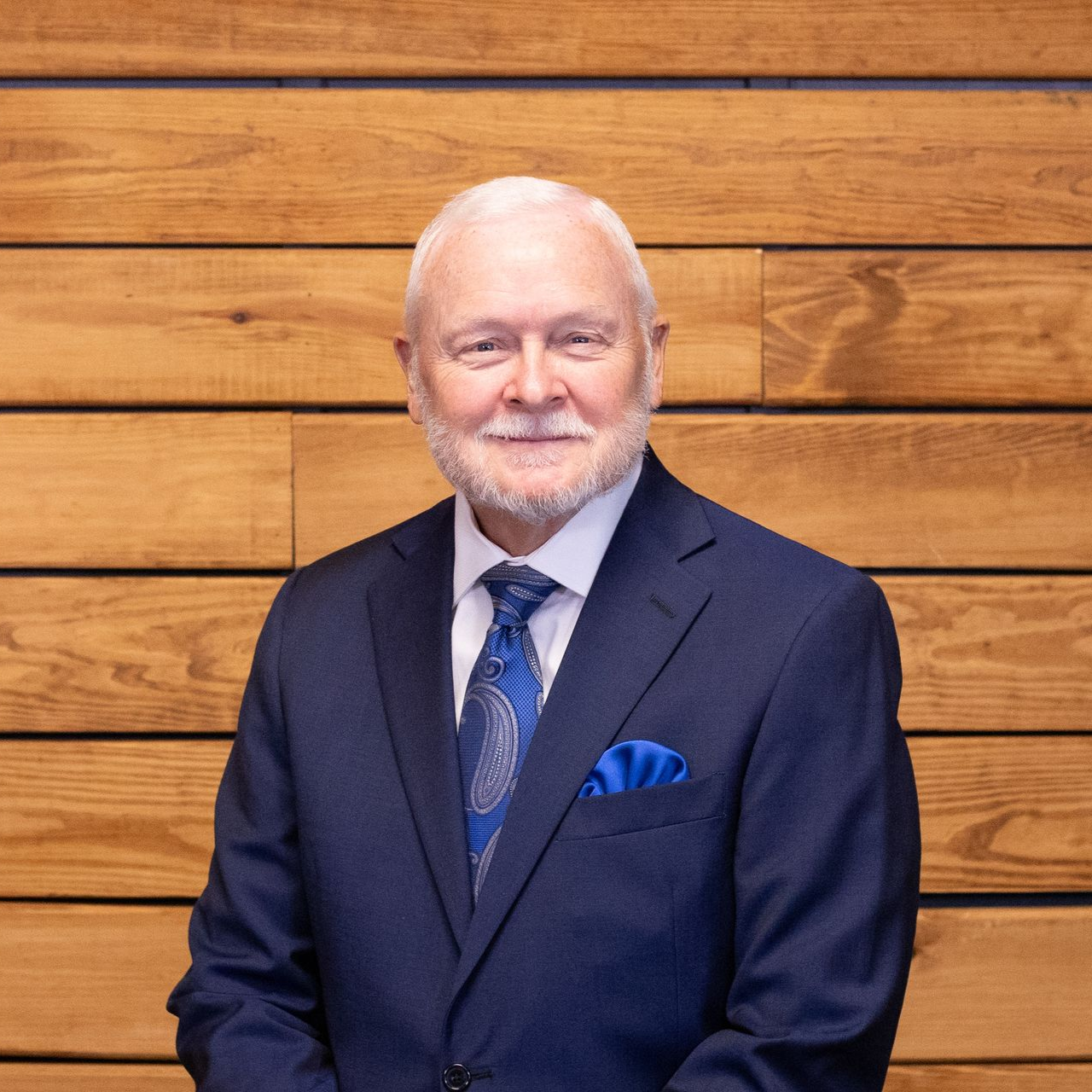 A man in a suit and tie is smiling for the camera.