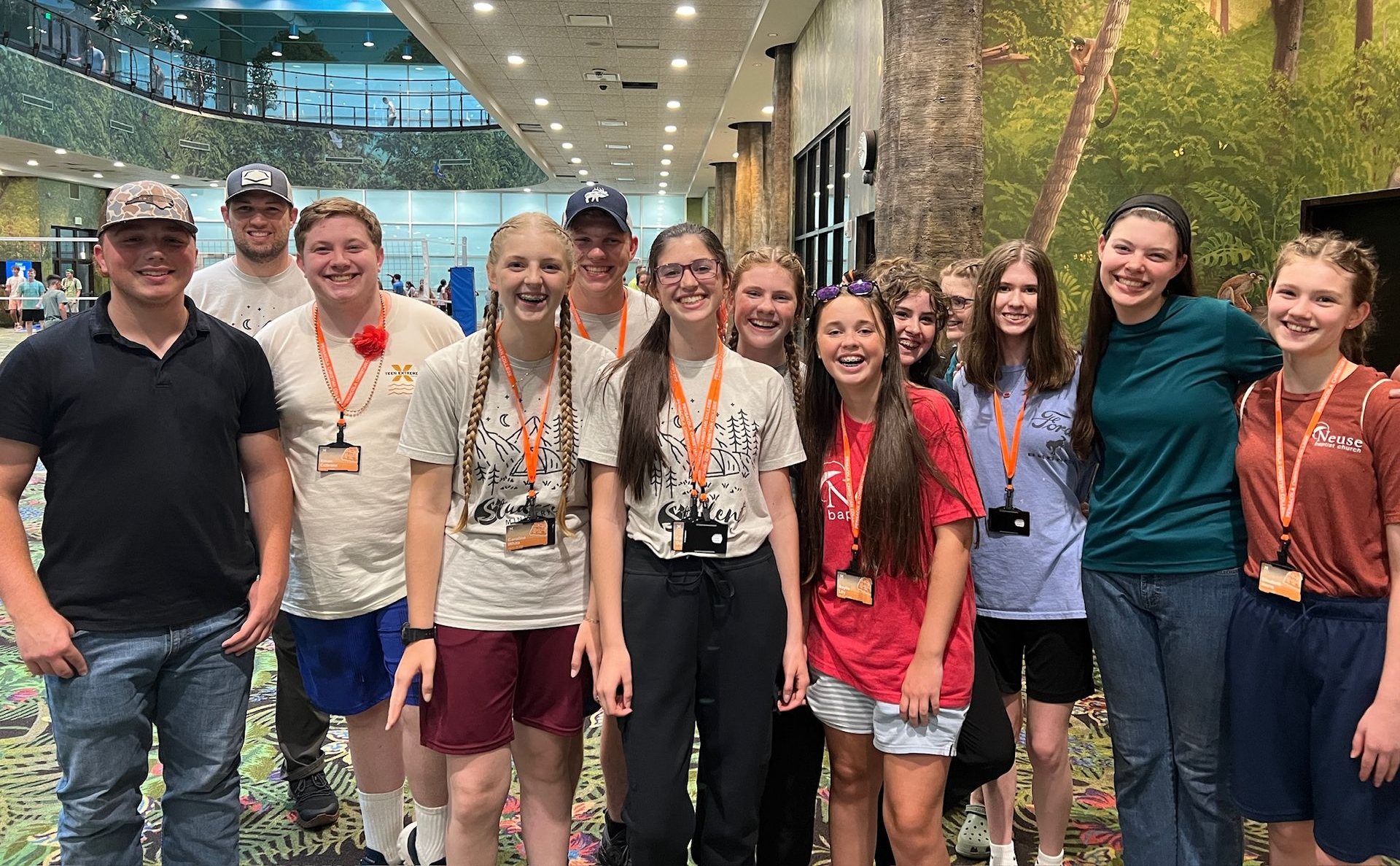 A group of young people wearing blue shirts are posing for a picture.