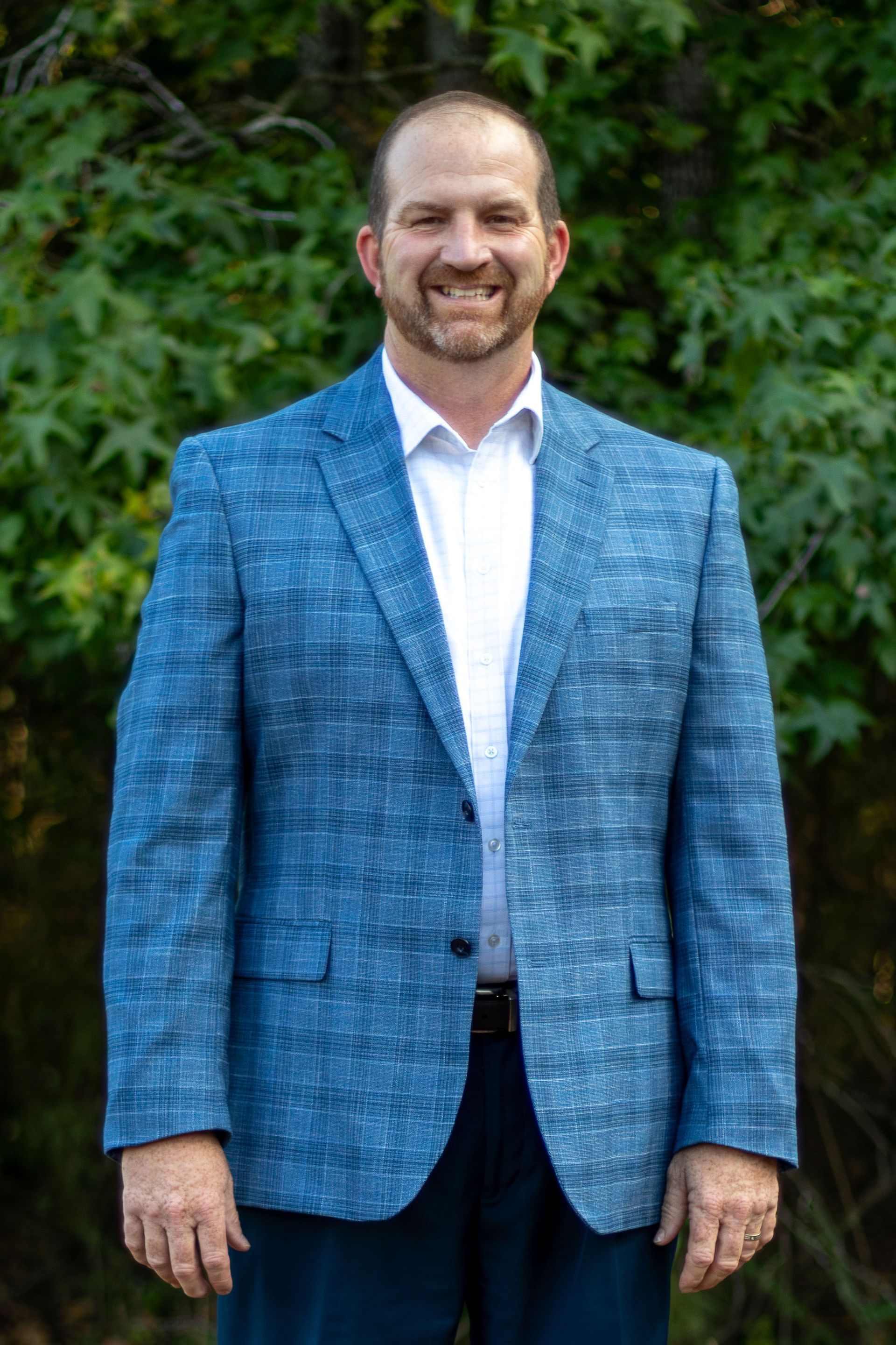 A man in a suit and tie is smiling for the camera.