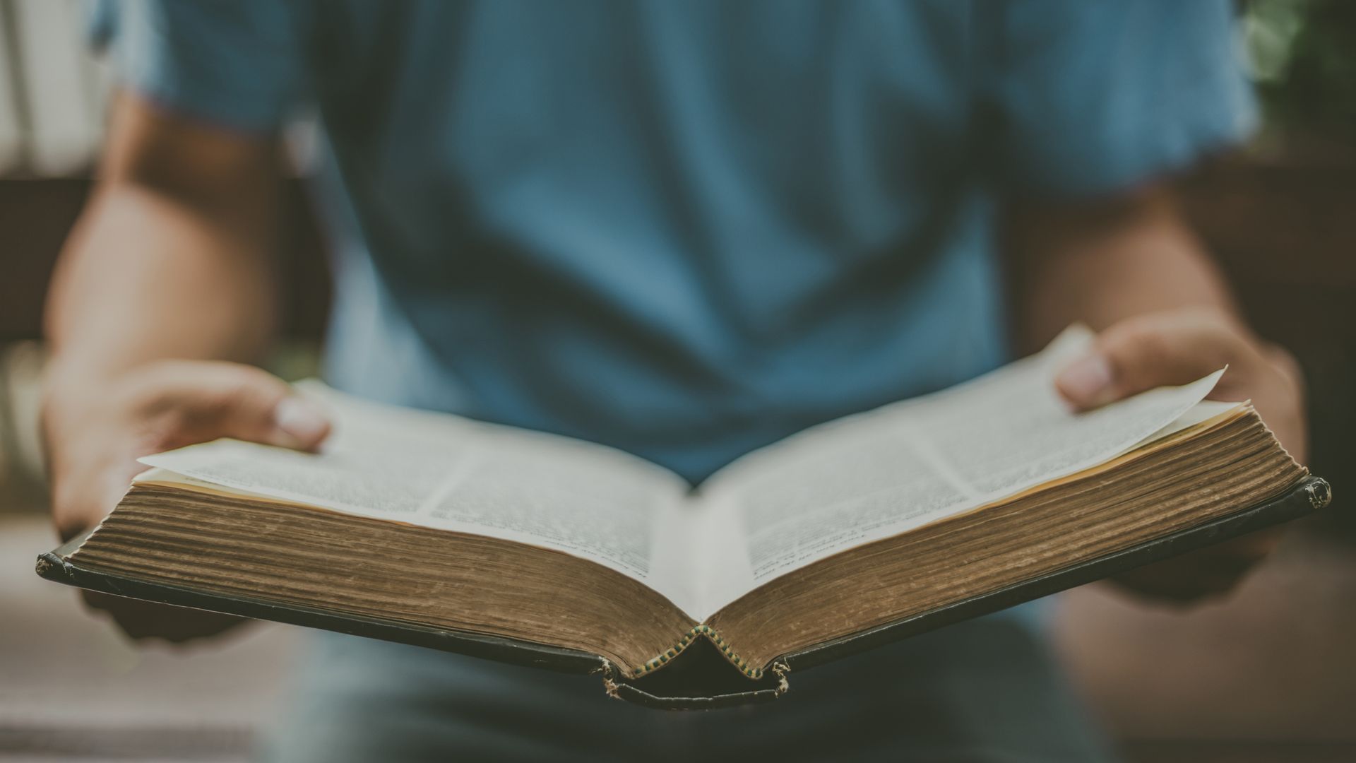person holding open Bible