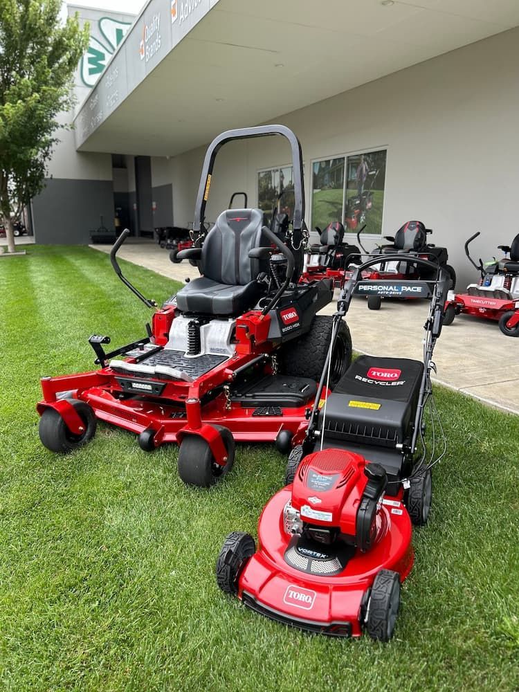 Two Lawn Mowers Are Parked in Front of a Building — Ireland's Machinery Pty Ltd in Braemar, NSW
