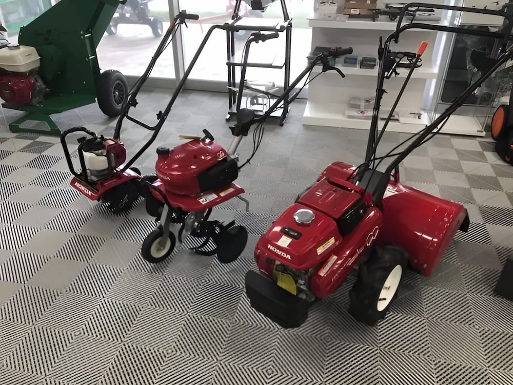 Three Red Lawn Mowers Are Sitting on a Checkered Floor in a Showroom — Ireland's Machinery Pty Ltd In Braemar, NSW