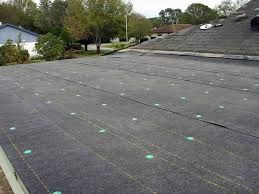 A roof with a lot of holes in it and trees in the background.