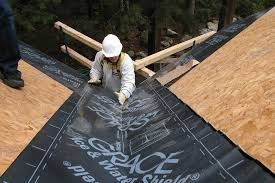 A man is working on a roof with a hard hat on.