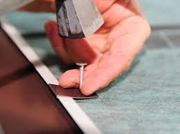 A person is hammering a nail into a piece of wood.