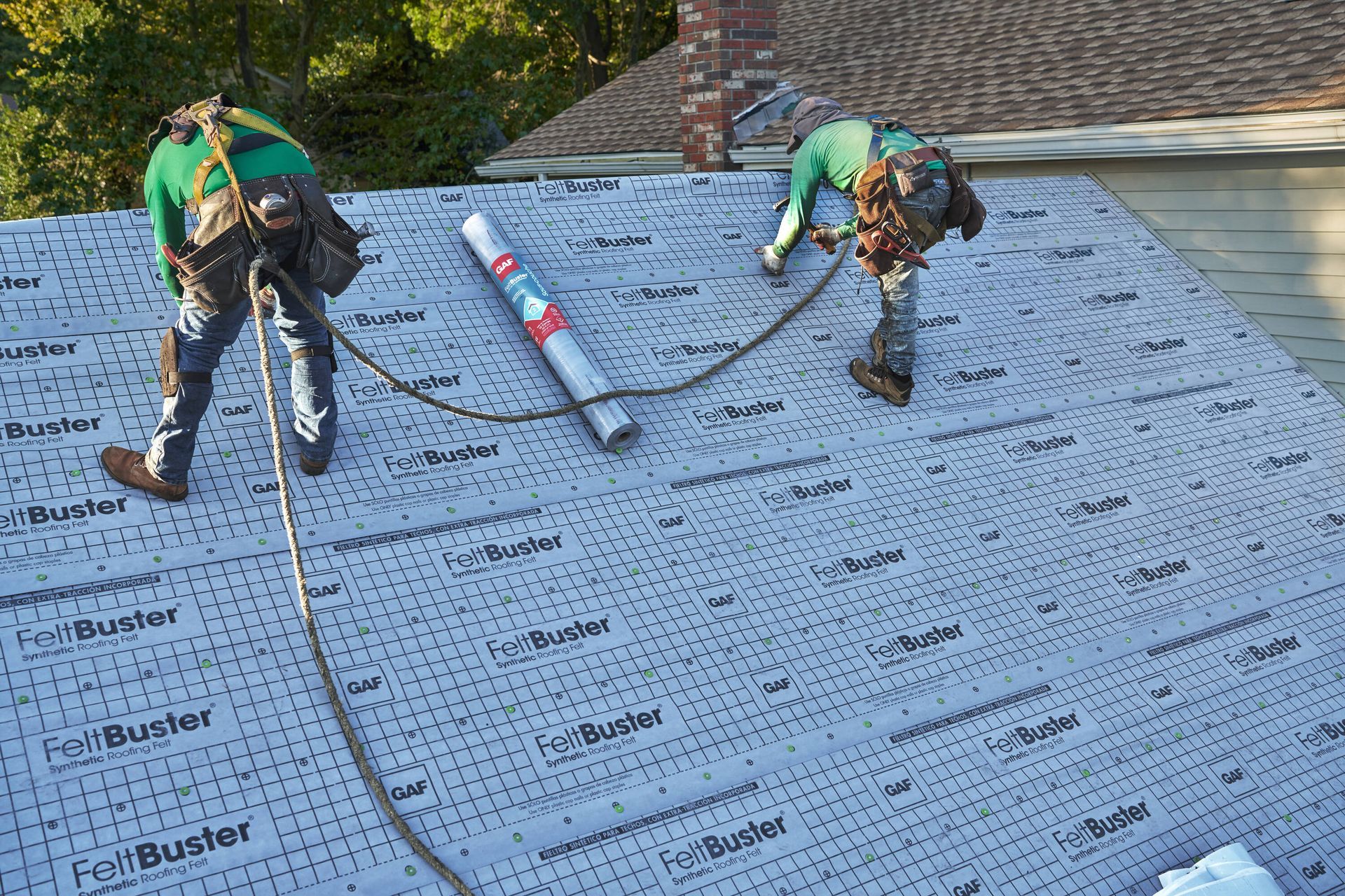 Two men are working on the roof of a house.