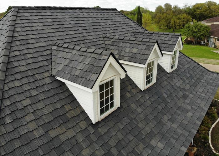 An aerial view of a house with a synthetic gray cedar shake roof 