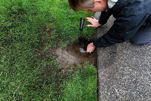 man fixing the  lawn sprinkler