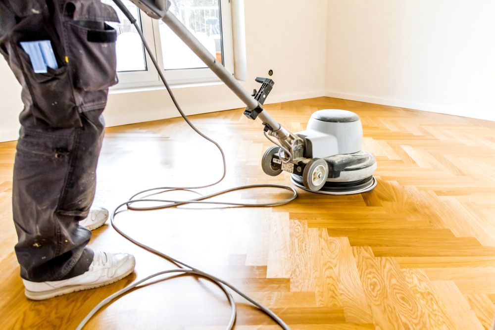 Person Sanding a Wooden Floor With a Floor Sander — Bowen Hire in Collinsville, QLD