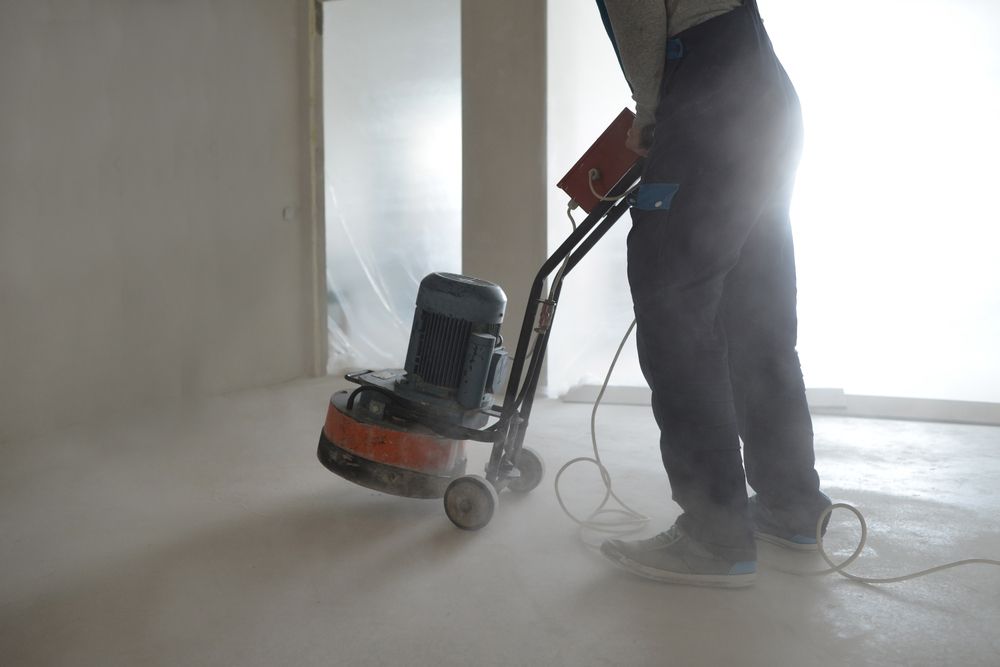 Person Using a Floor Grinder in a Dusty Room — Bowen Hire in Collinsville, QLD