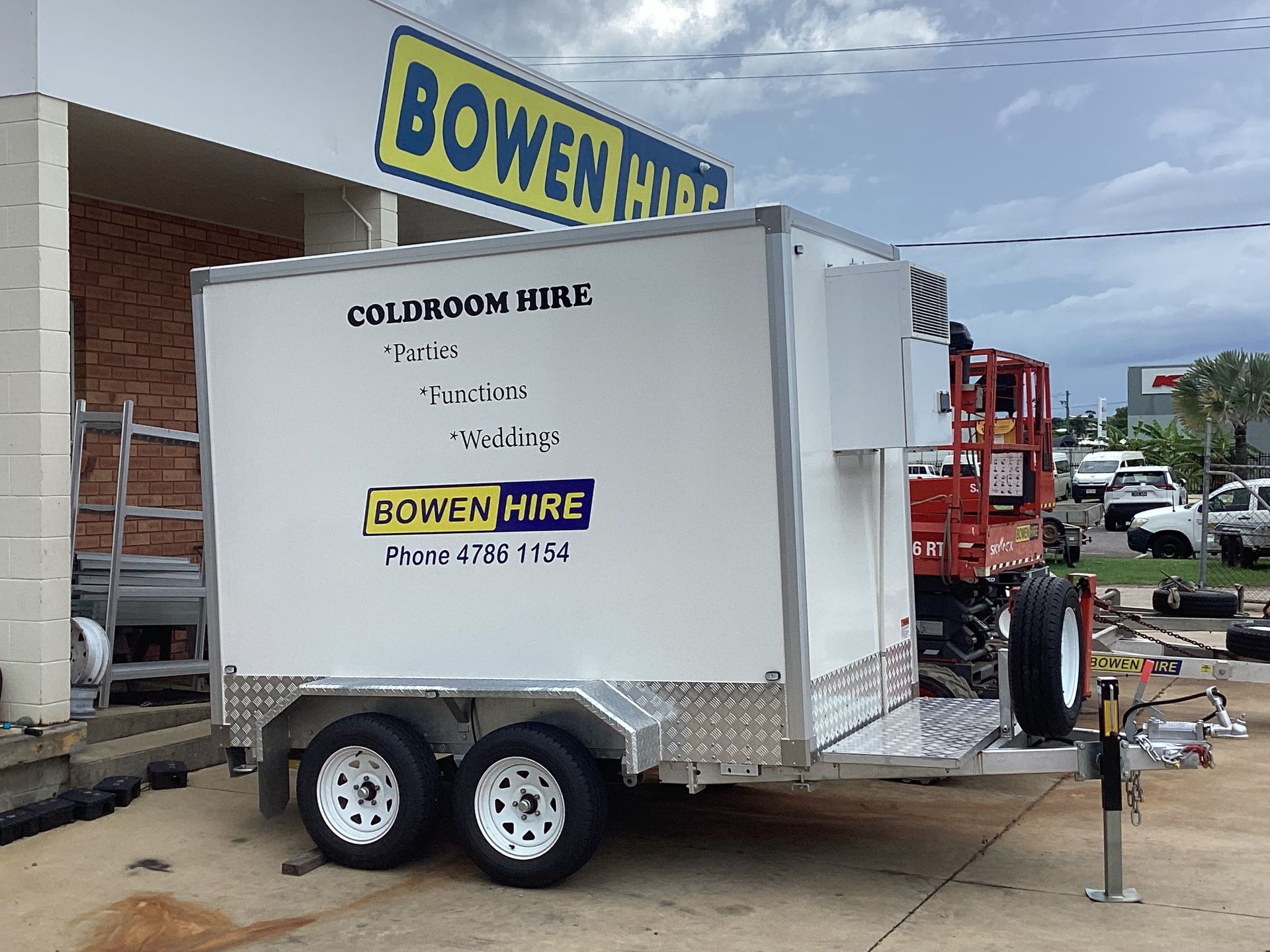 White Bowen Hire Trailer Parked Outside a Building With a Yellow Sign — Bowen Hire in Bowen, QLD