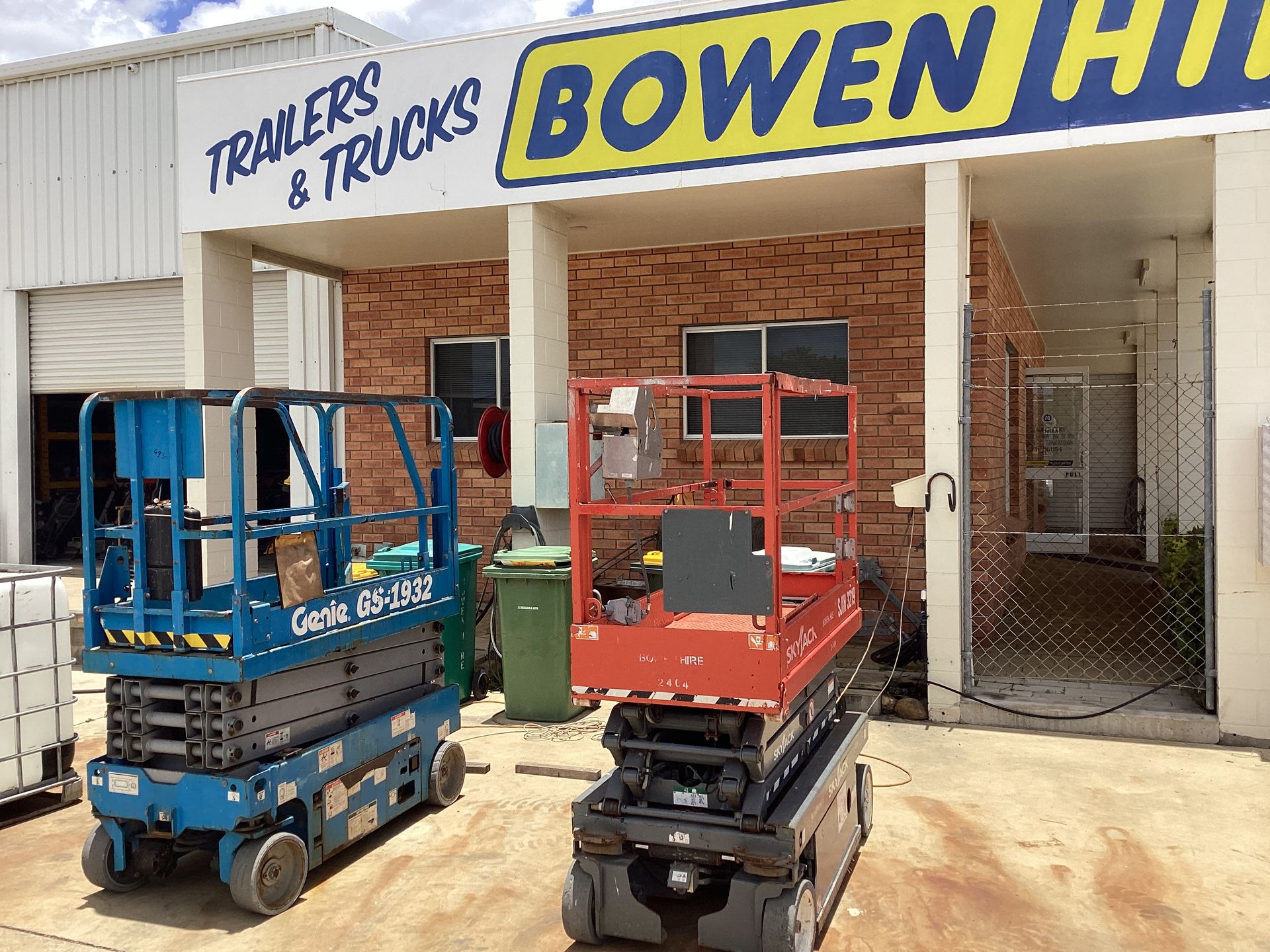 Two Scissor Lifts Parked Outside a Truck Hire Shop With a Yellow Bowen Sign — Bowen Hire in Bowen, QLD