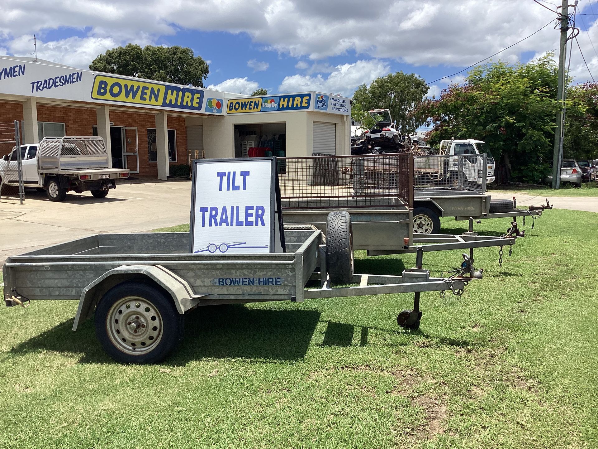 Tilt Trailer Parked on Grass Outside Bowen Hire, With Other Trailers in the Background — Bowen Hire in Bowen, QLD