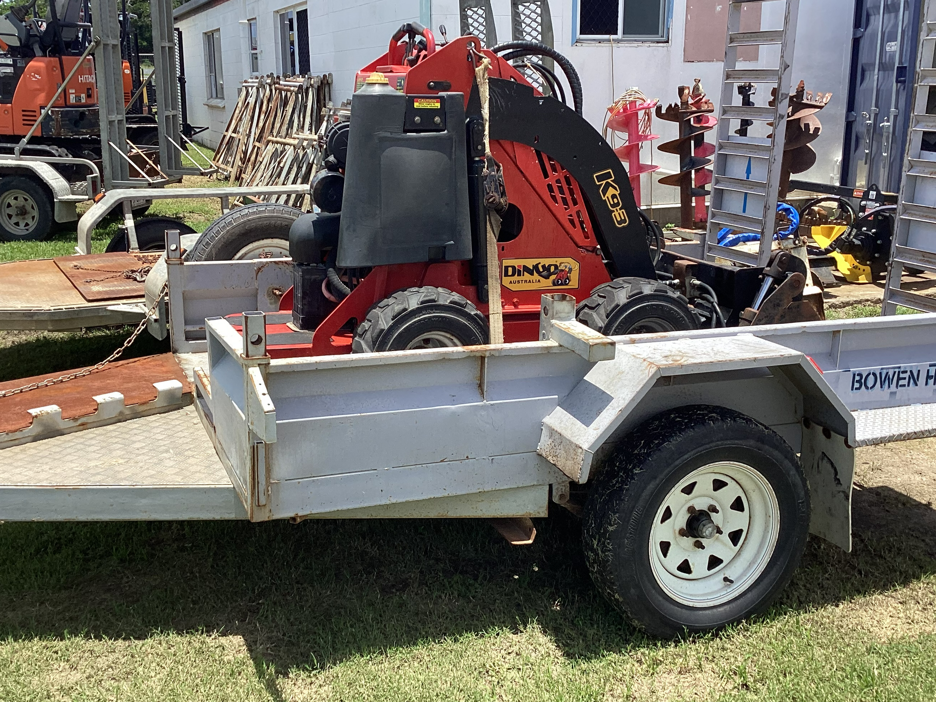 Red Compact Excavator Loaded on a Silver Trailer in an Outdoor Work Yard — Bowen Hire in Bowen, QLD