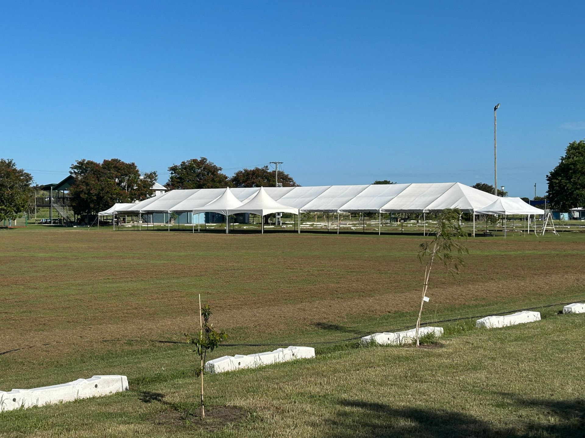 Large White Event Tent on a Grassy Field Under a Clear Blue Sky — Bowen Hire in Bowen, QLD