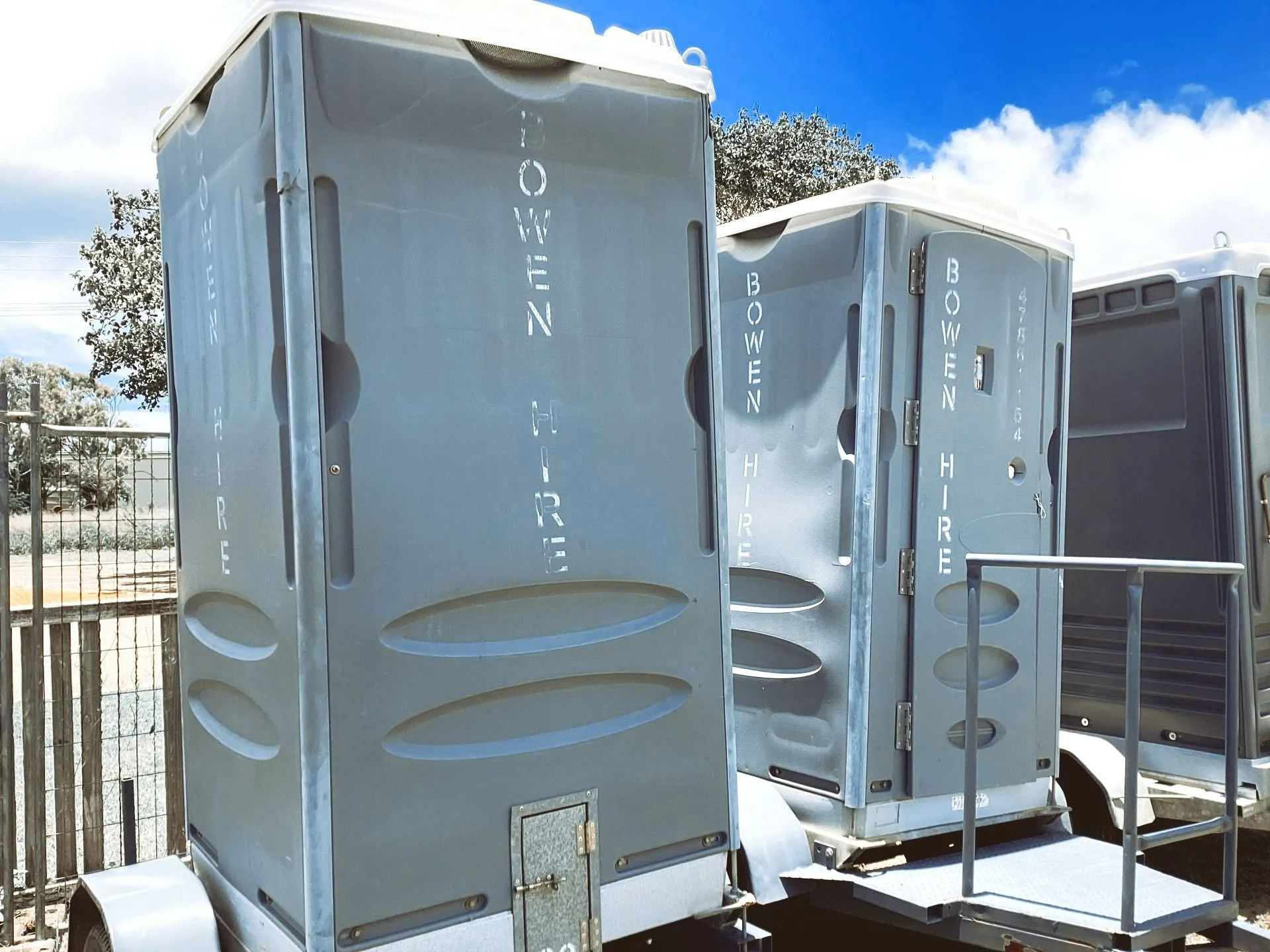 Two Grey Portable Toilets With Bowen Hire Branding — Bowen Hire in Proserpine, QLD