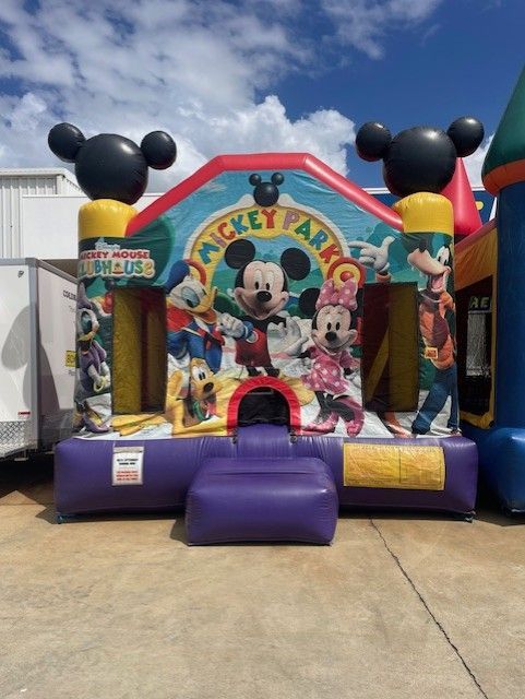 Mickey Mouse bounce house with purple slide and colorful Mickey-themed arch at an outdoor event - Bowen Hire in Bowen, QLD