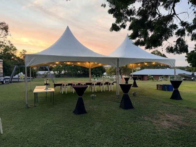 Outdoor Event Tent at Sunset with Cocktail Tables on A Grassy Lawn — Bowen Hire in Proserpine, QLD