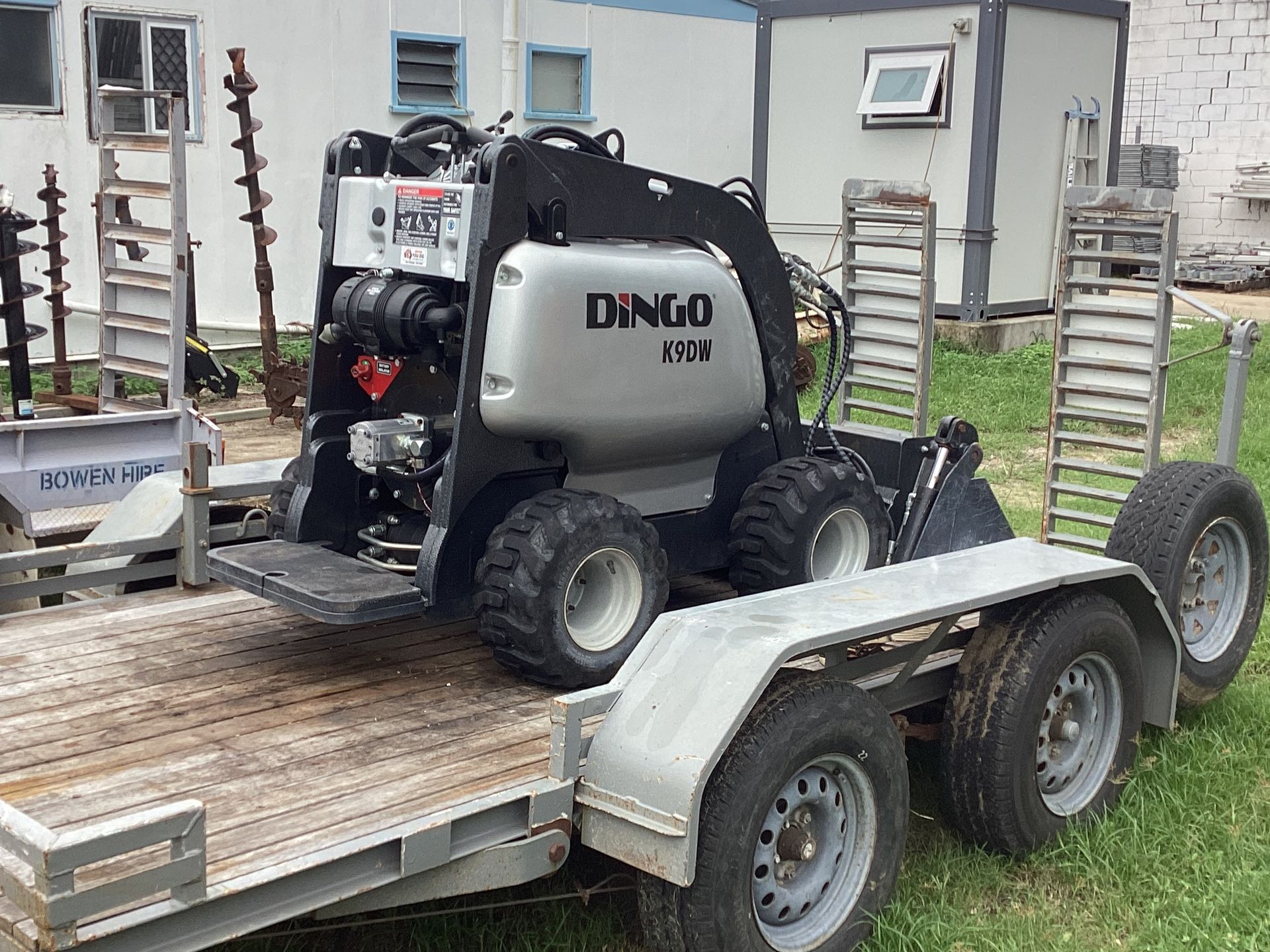 Grey Nano Atv Farm Vehicle Strapped on a Flatbed Trailer Outside a Building — Bowen Hire in Bowen, QLD