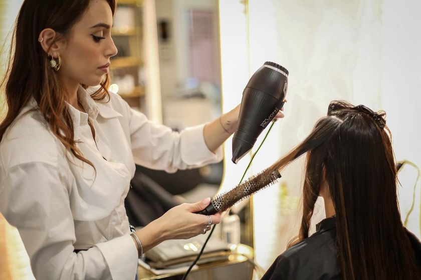 parrucchiera asciuga i capelli a una cliente