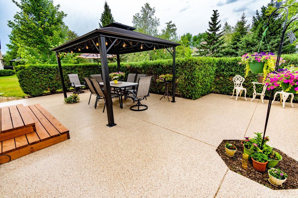 A patio with a gazebo and a table and chairs