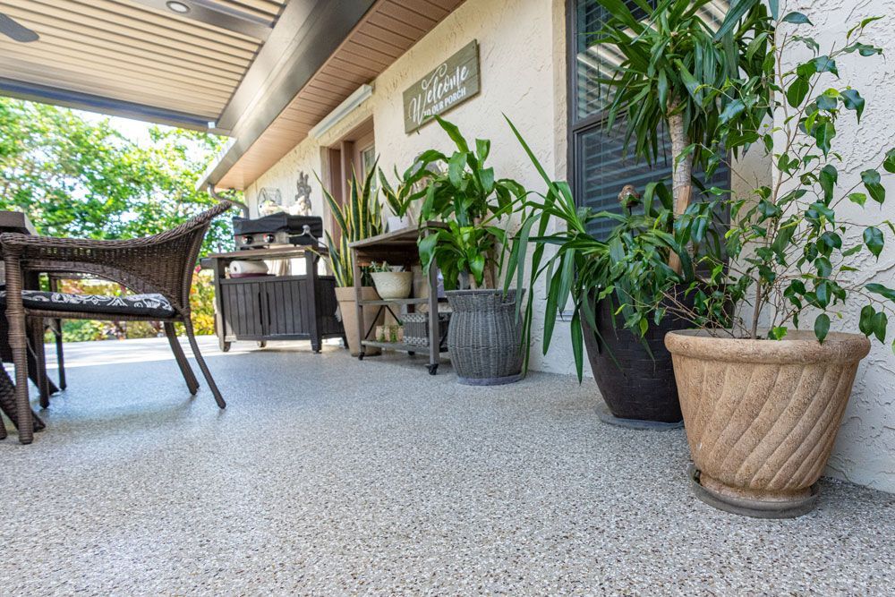 A patio with a table and chairs and potted plants.