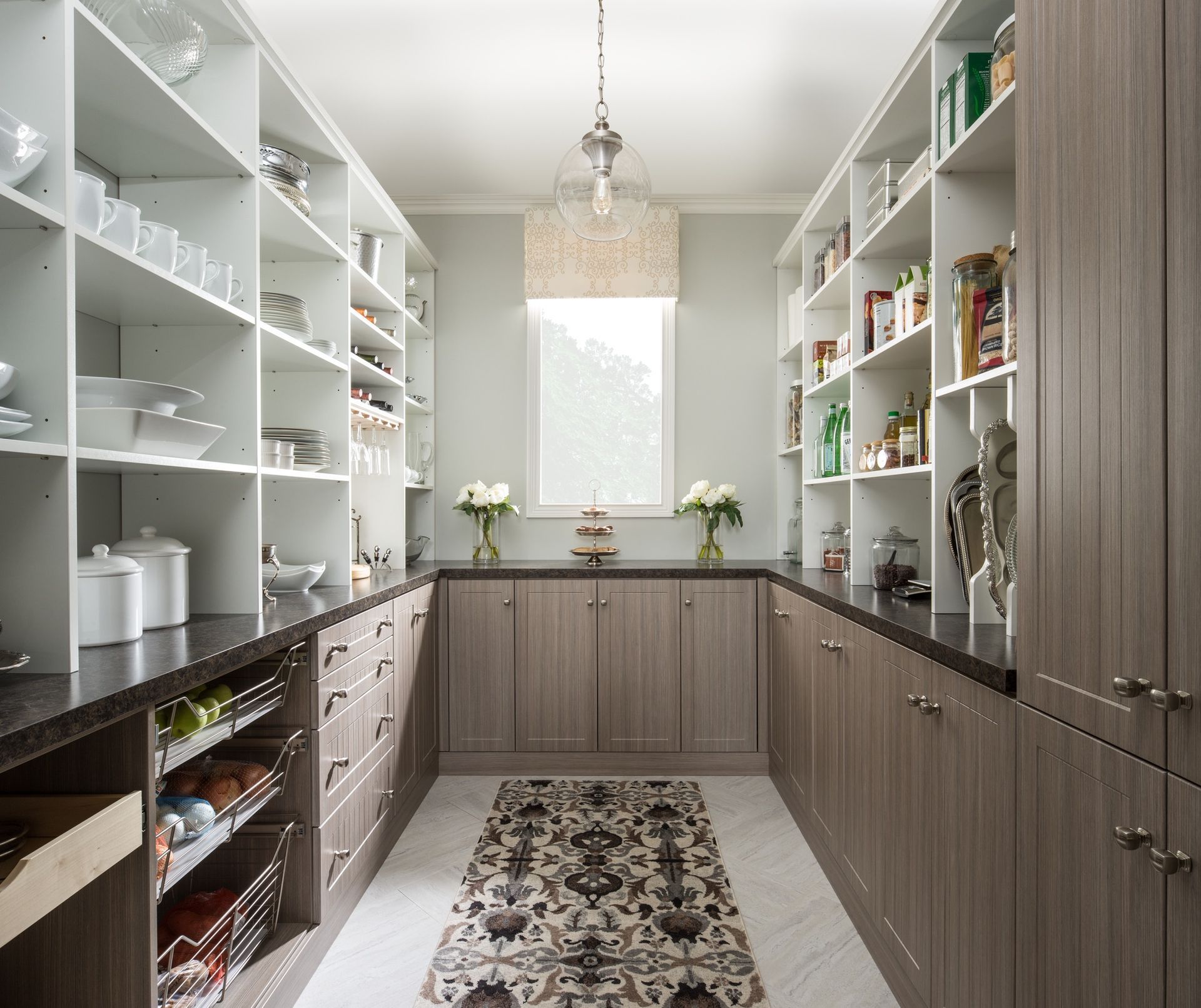 A kitchen with lots of shelves and cabinets and a rug on the floor
