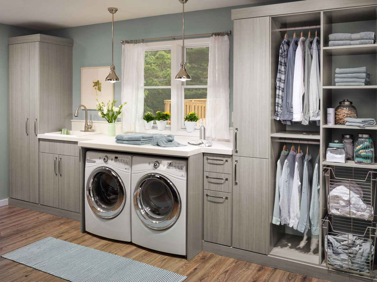 A laundry room with a washer and dryer , cabinets , shelves and a window.