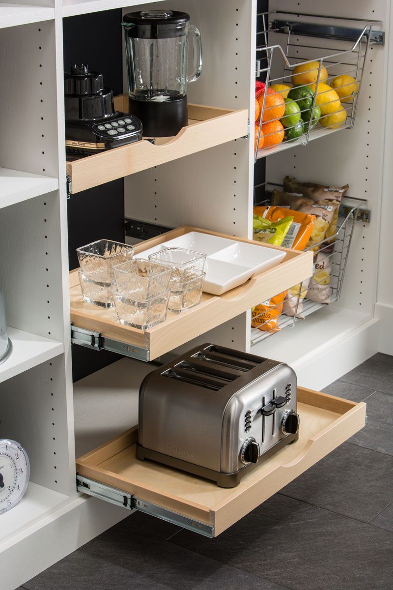 A toaster oven is pulled out of a drawer in a pantry.