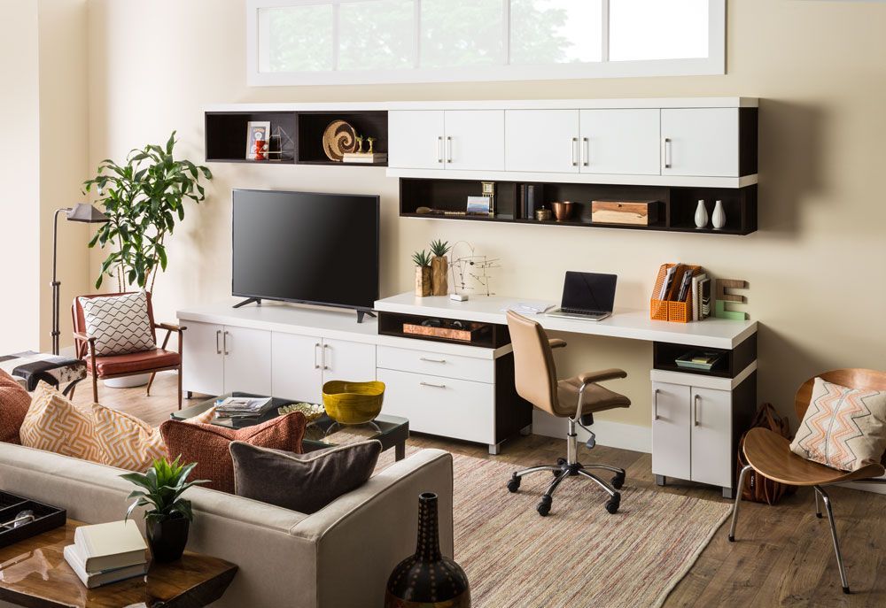 A living room with a couch , desk , chair and television.