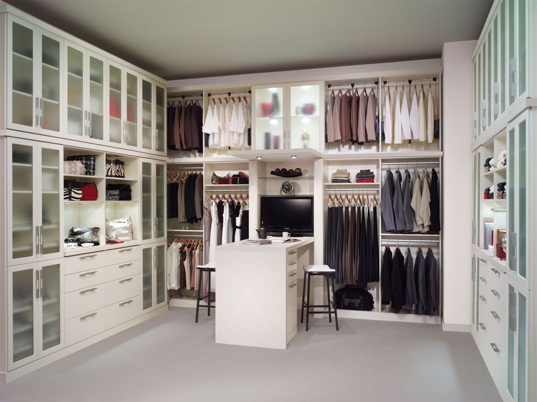 A walk in closet with lots of clothes and a tv