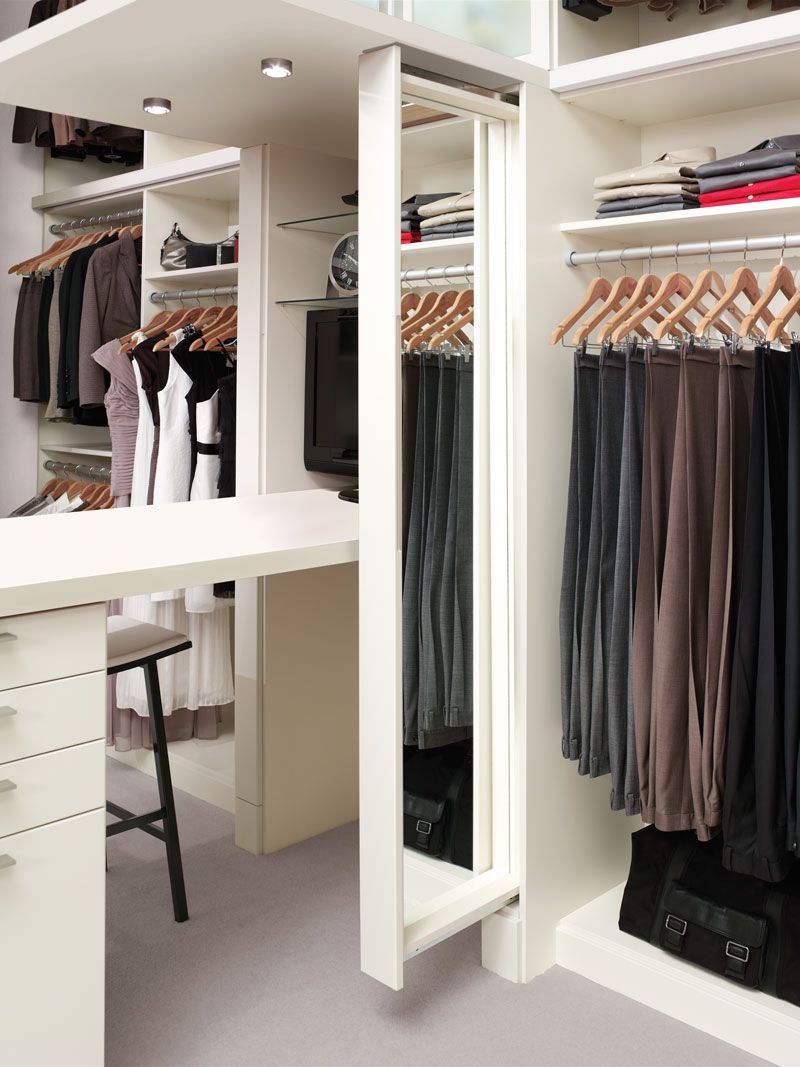 A walk in closet with clothes hanging and a mirror