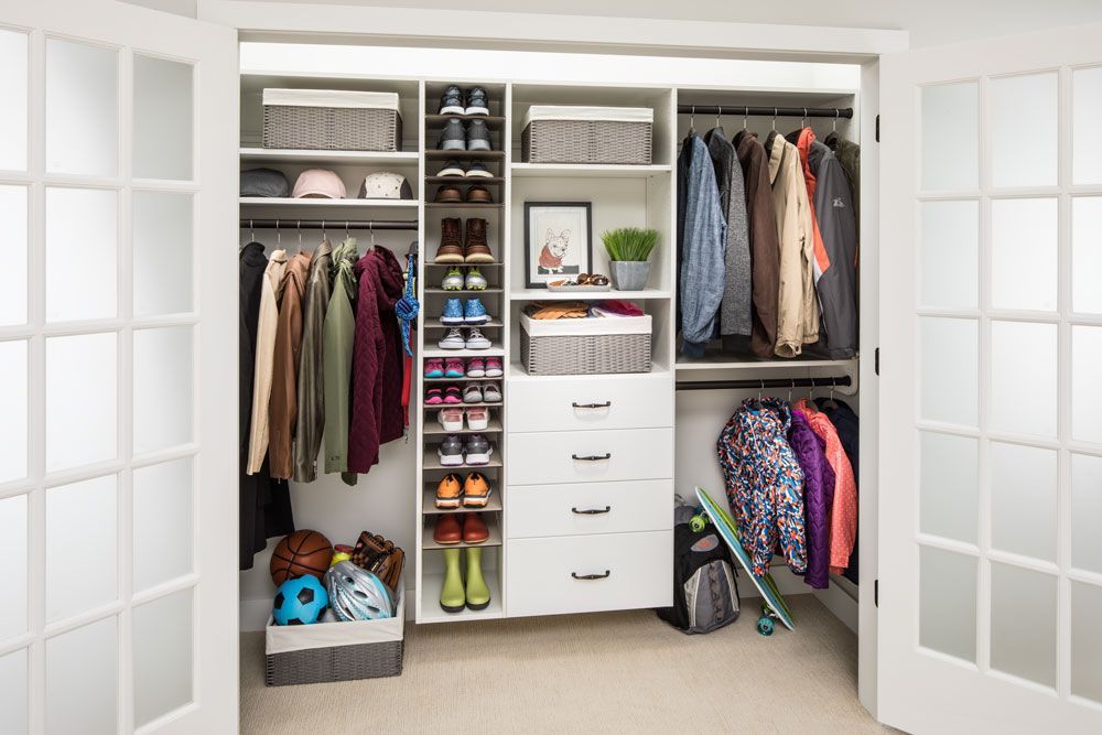 A reach-in closet filled with lots of clothes and shoes.