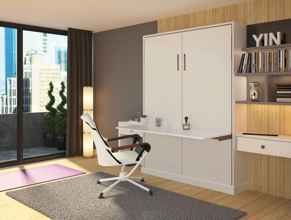 A bedroom with a wall mounted desk and chair.