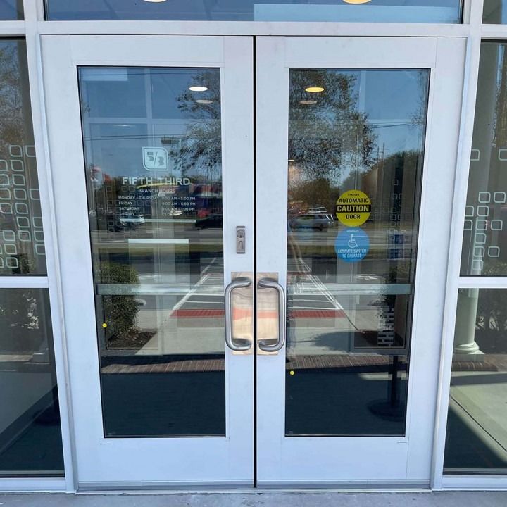Glass double doors with metal handles and reflective windows at a building entrance